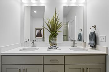 A bathroom with two sinks and a mirror.